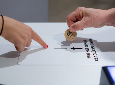 Einwurf einer Münze bei der Coin and Win Aktion bei der Neueröffnung von einer C&A Filiale