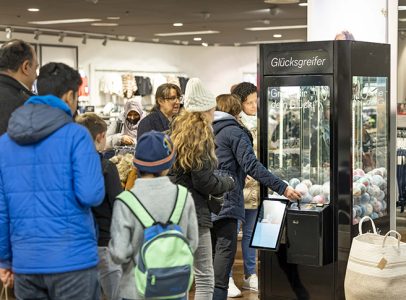 Personen stehen an um die Social Grabbing Machine zu verwenden